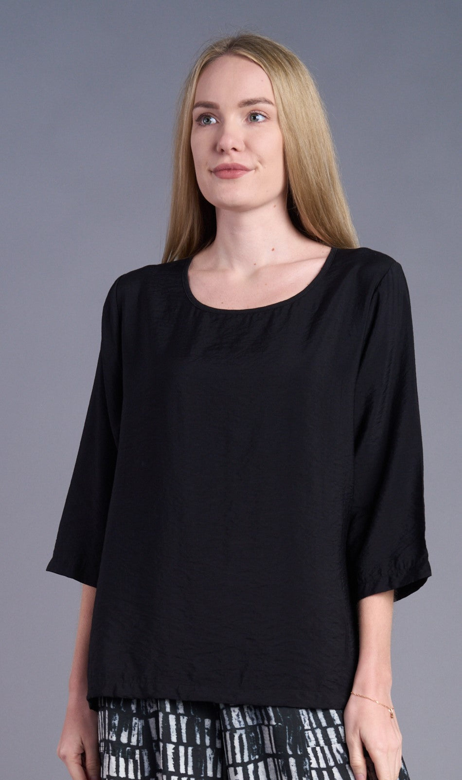 Close-up of black 3/4 sleeve blouse on a woman with long blonde hair