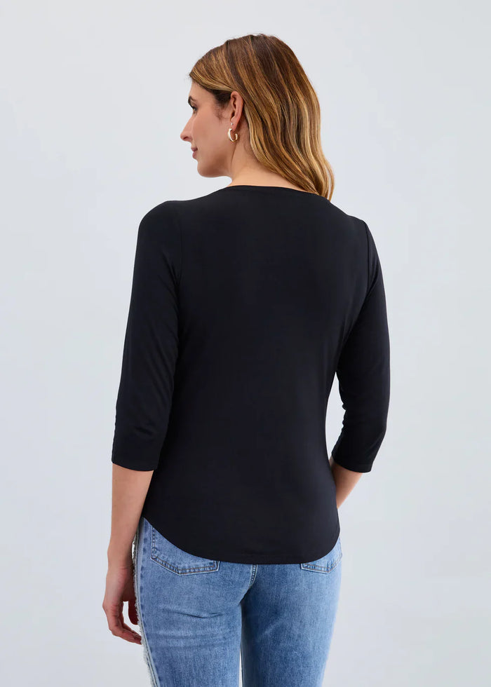 Back view of a black V-neck 3/4 sleeve women's top paired with jeans