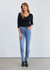Woman wearing a classic black V-neck 3/4 sleeve top with blue jeans and black boots