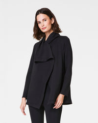 Close-up of cardigan pocket and sleeve details in soft black fabric