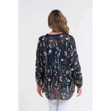 Back view of a navy blue floral sheer blouse showcasing the vibrant pattern