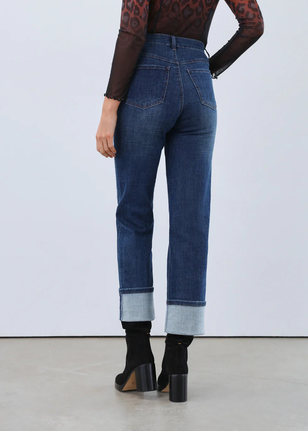 Back view of high-waisted jeans with extra-wide cuffs showcased by model