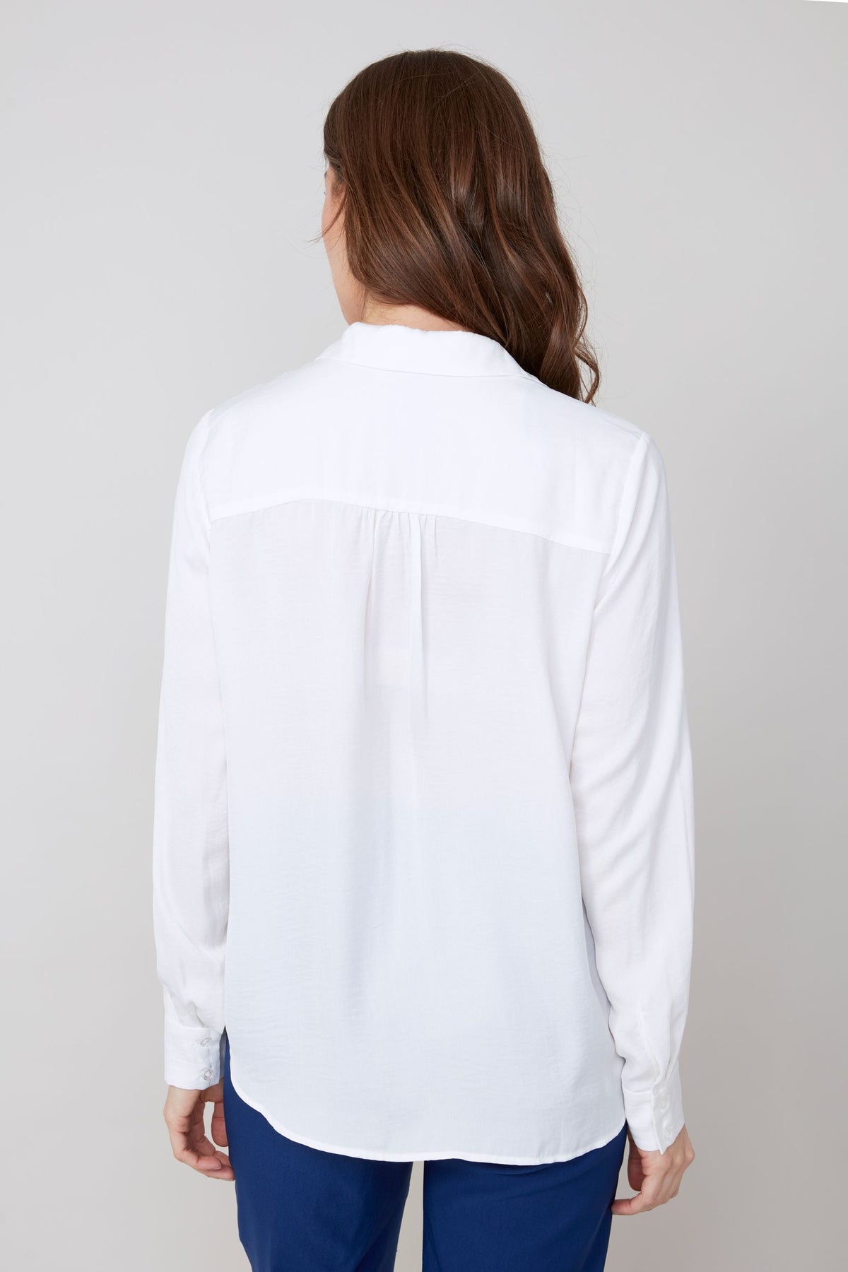 Back view of white button-up blouse with long sleeves