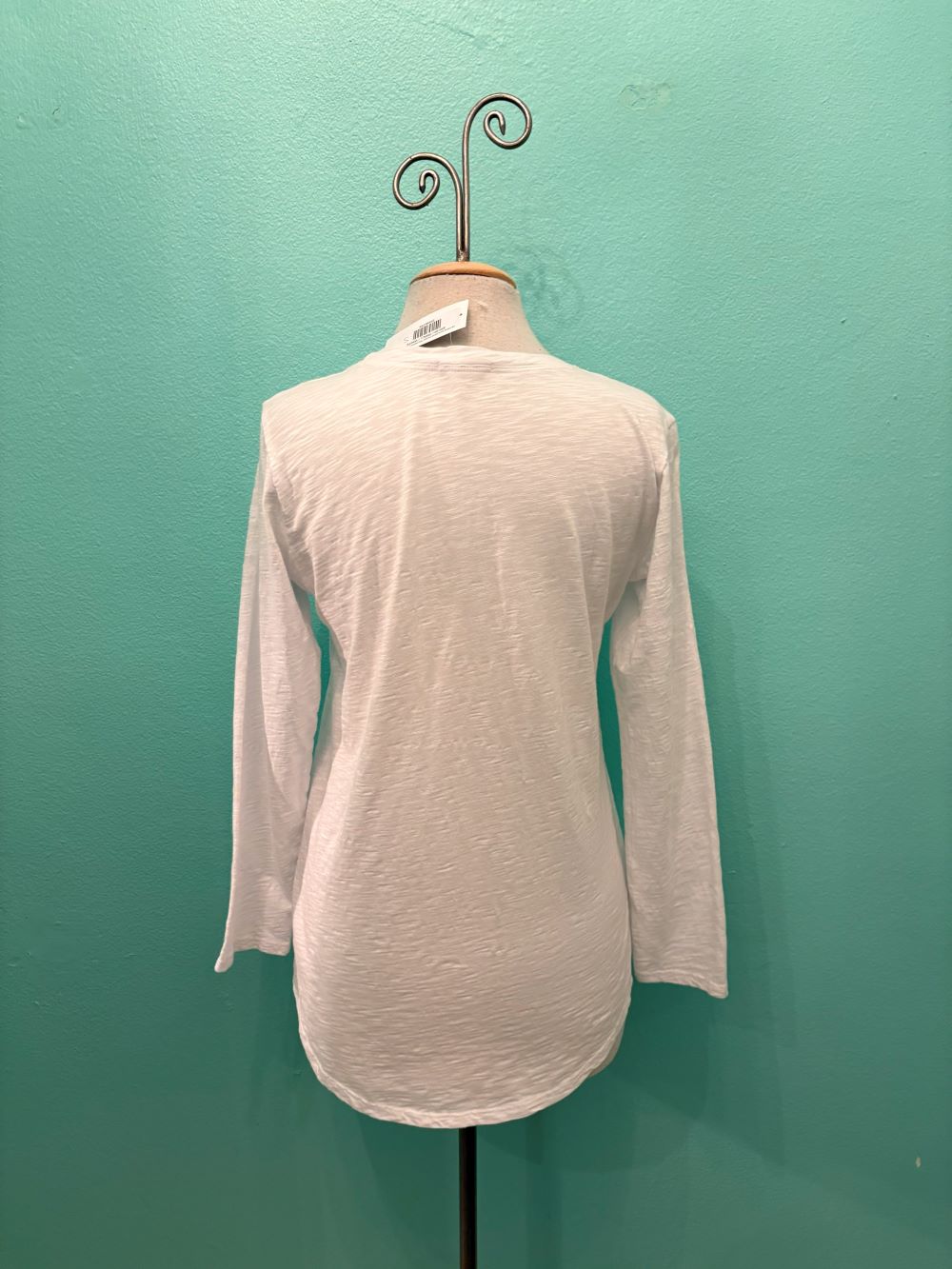 Back view of classic white long sleeve pocket tee on mannequin