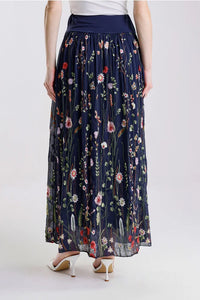 Back view of navy floral embroidered maxi skirt, styled with white heels