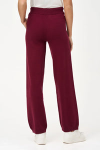 Back view of woman wearing burgundy relaxed-fit knit jogger pants