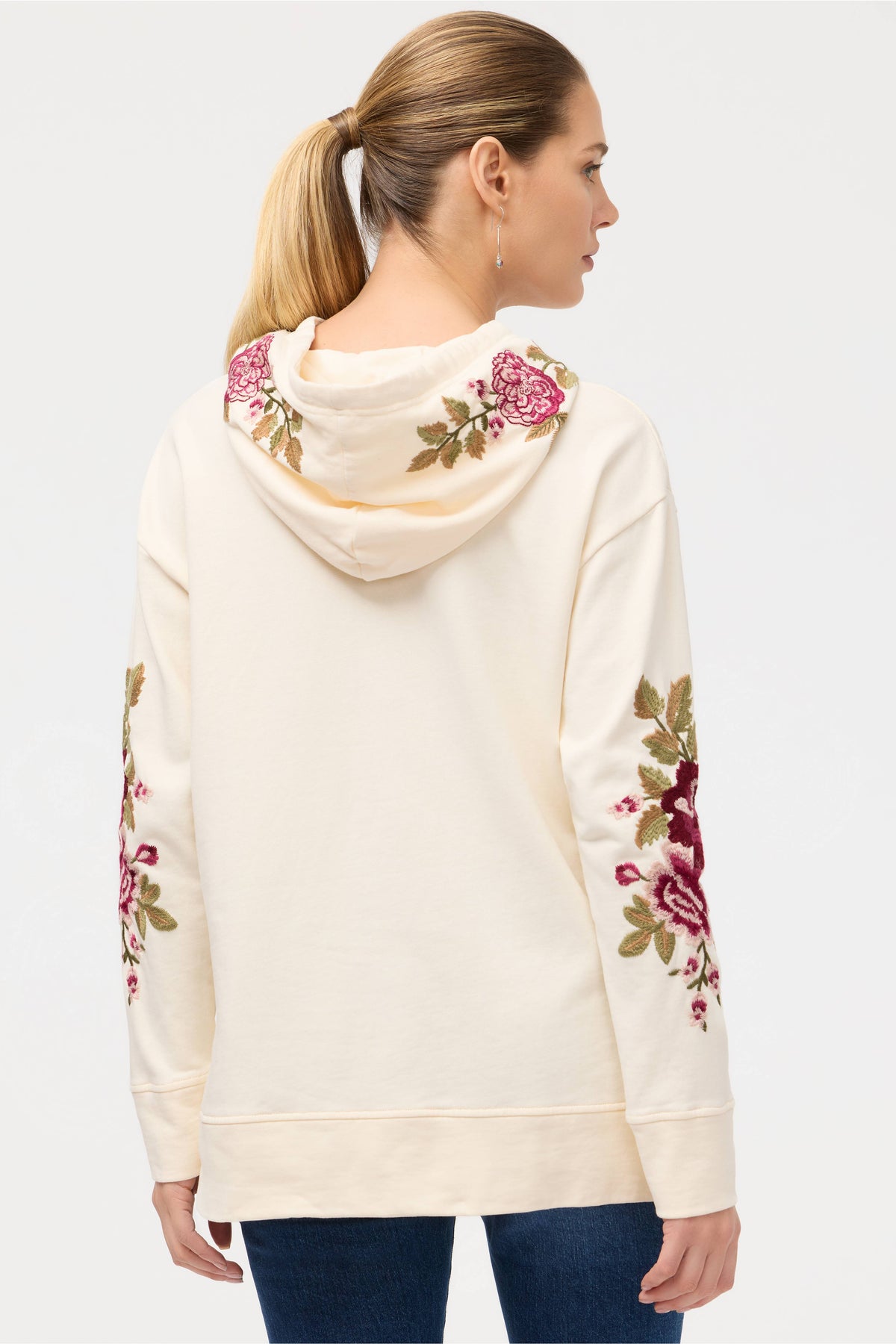 Back view of a cream hoodie featuring pink and green rose embroidery on hood and sleeves
