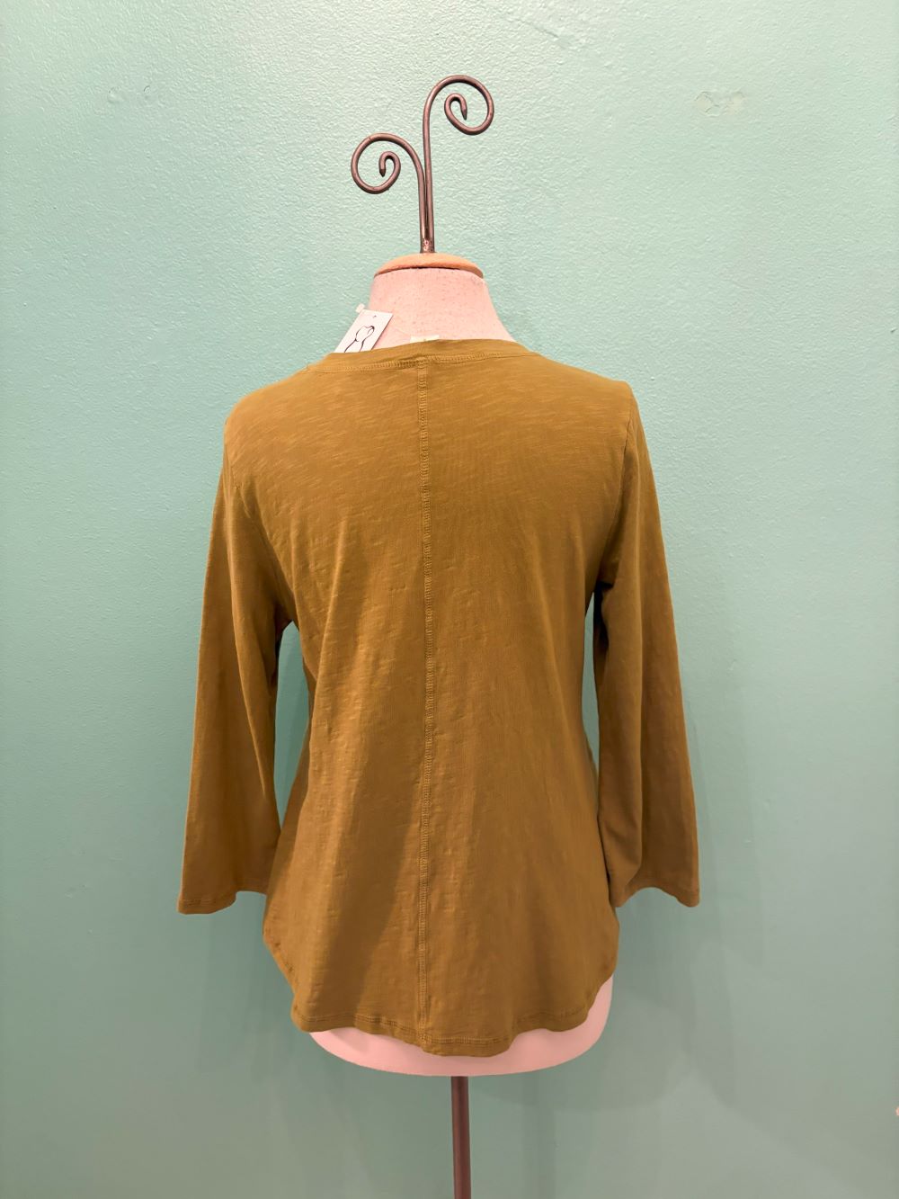 Back view of olive green relaxed-fit long sleeve top on mannequin