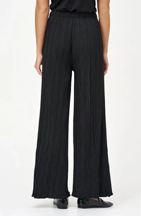 Back view of black wave-textured wide-leg pants worn by a model