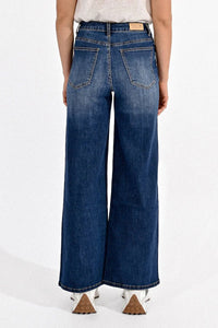 Back view of a woman wearing Molly Bracken wide leg blue jeans with a high-rise fit