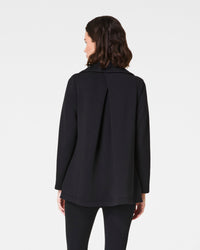 Rear view of woman wearing black cardigan showing back pleat detail