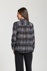 Back view of a woman wearing a black blouse with an all-over metallic diamond pattern