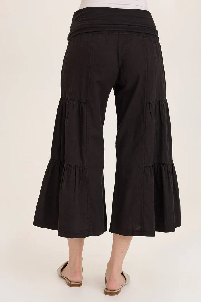 Back view of flowy tiered black culotte pants worn with flats