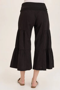 Back view of flowy tiered black culotte pants worn with flats