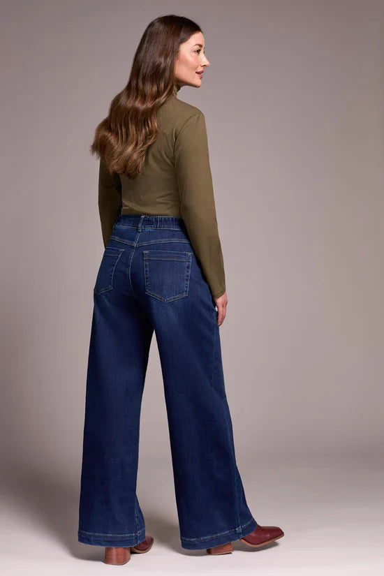 Model wearing high-rise wide leg jeans shown from the back with olive turtleneck