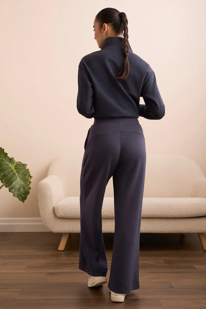 Back view of model wearing navy wide-leg lounge pants and zip-up pullover
