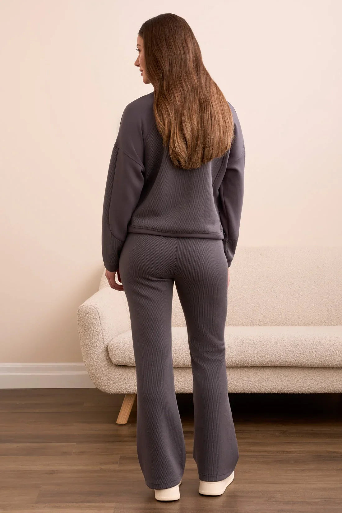 Back view of a woman wearing a ribbed slate grey lounge set with flared pants