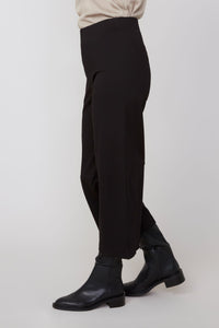 Side profile showcasing the relaxed fit and ankle length of black cropped pants