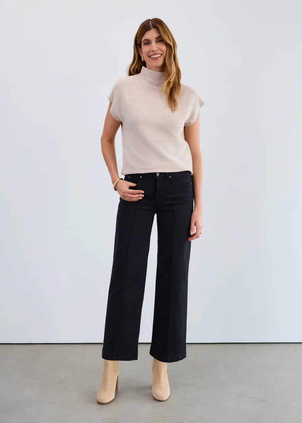 Woman wearing black high-rise wide leg jeans with short sleeve beige top