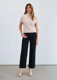 Woman wearing black high-rise wide leg jeans with short sleeve beige top