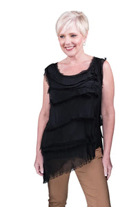 Woman wearing a sleeveless black tiered asymmetric hem top with brown pants