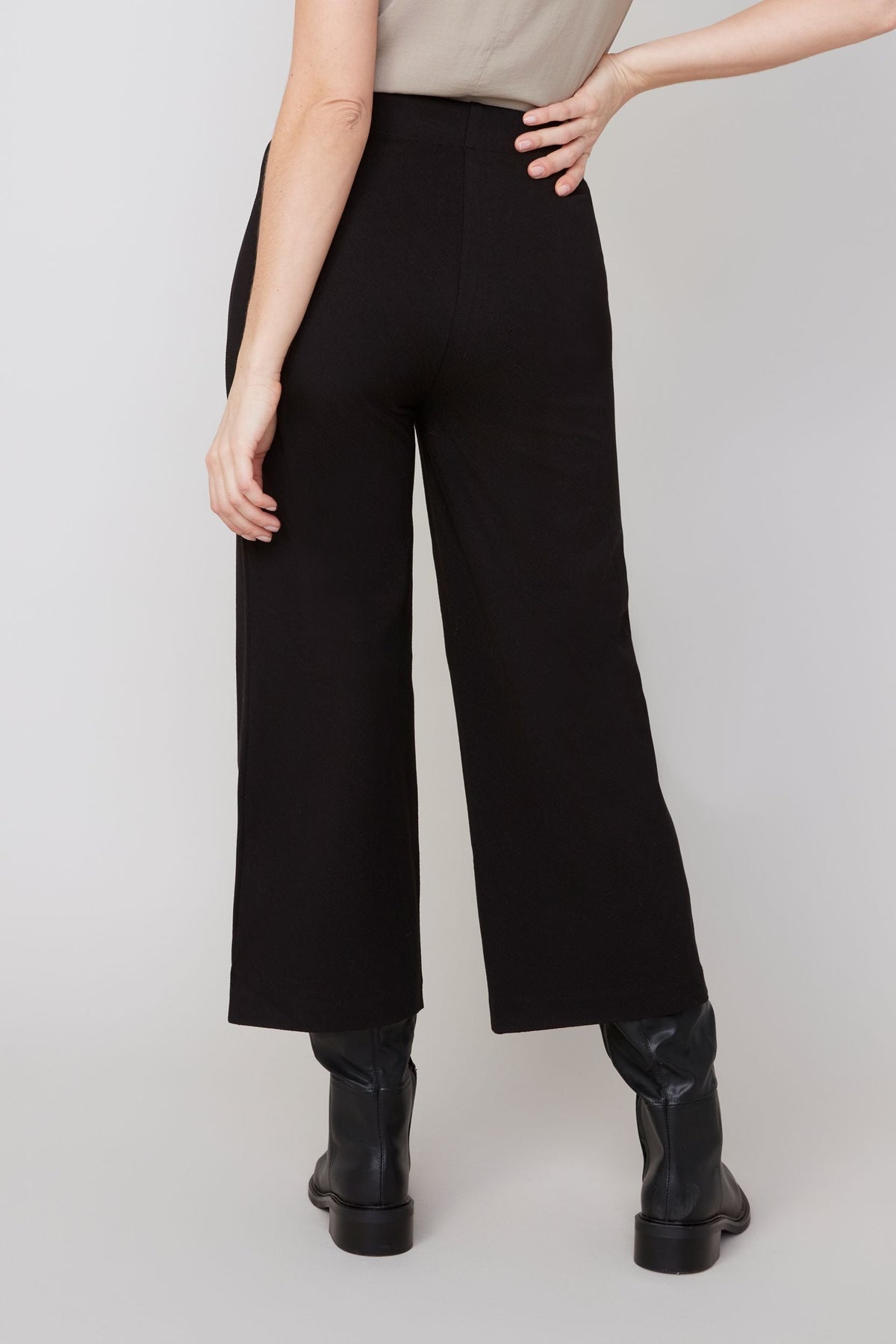 Back view of black wide-leg cropped pants highlighting high waist design
