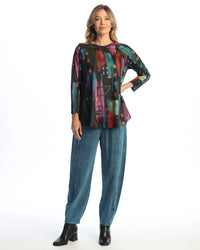 Model wearing blue cloud wash easy pants paired with a colorful top and black boots