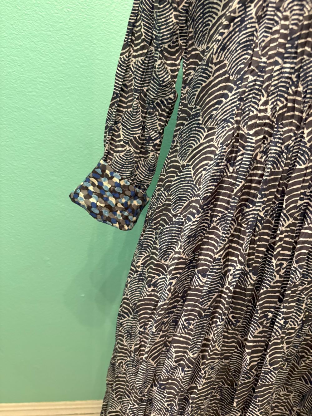 Sleeve detail showing blue geometric cuff on patterned midi dress