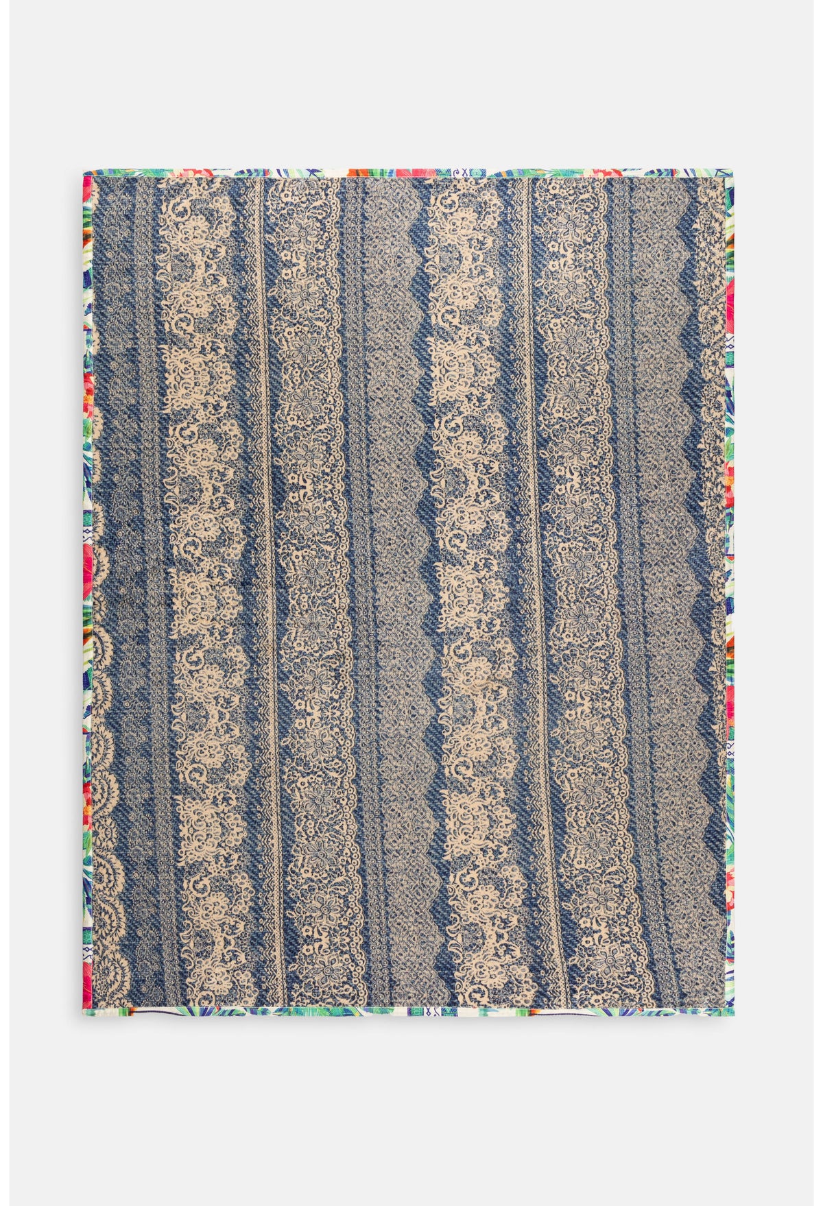 Close-up of colorful button and village details on travel blanket