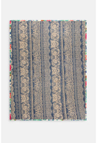 Close-up of colorful button and village details on travel blanket