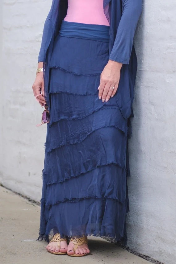 Woman in blue layered boho maxi skirt styled with pink top and blue cardigan