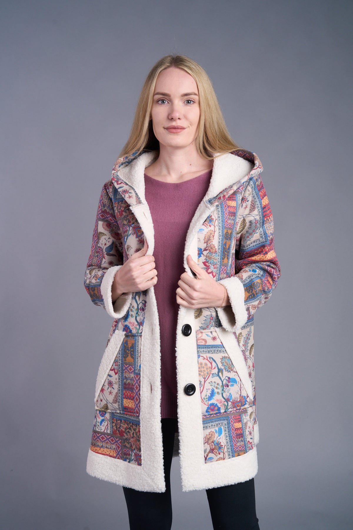 Woman wearing a boho patchwork sherpa-lined hooded coat in vibrant colors