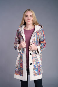 Woman wearing a boho patchwork sherpa-lined hooded coat in vibrant colors