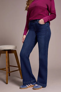 Side view of woman in bootcut jeans styled with purple striped sweater