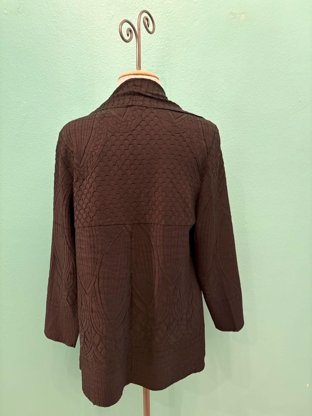 Back view of deep brown textured knit cardigan with scale-like pattern