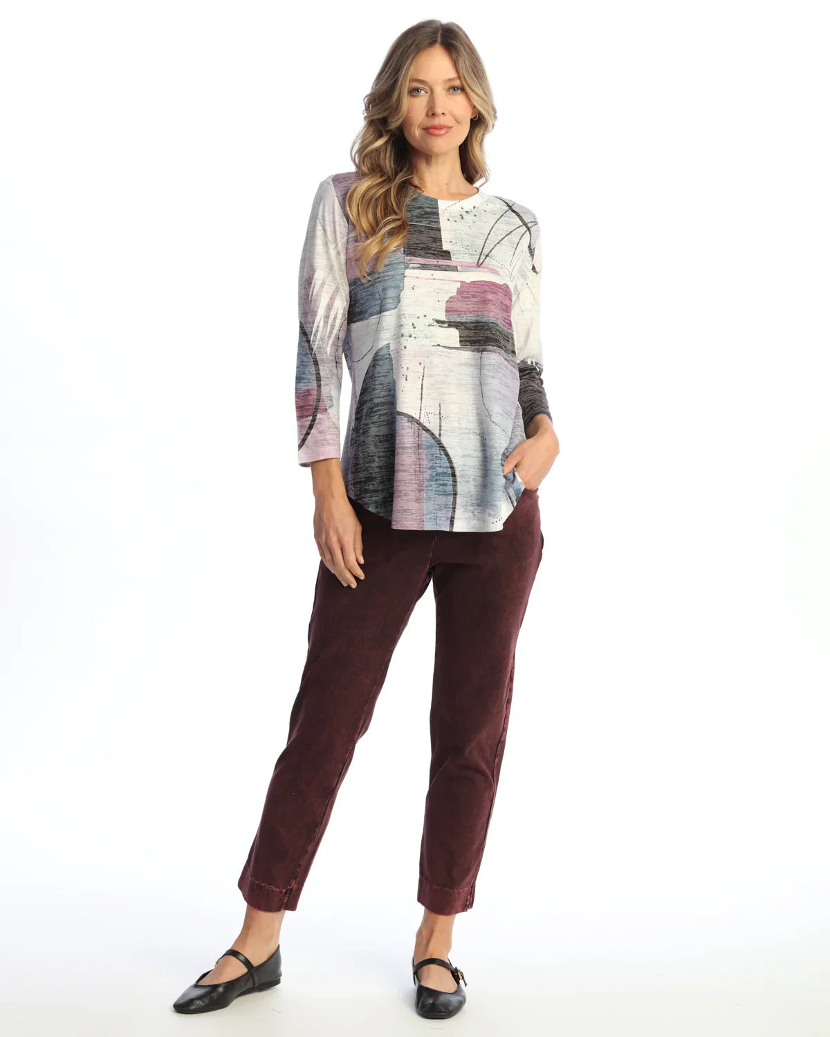 Woman modeling burgundy ankle pants paired with an abstract print top