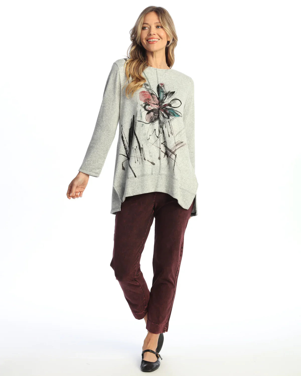 Woman wearing burgundy ankle pants styled with a gray floral top