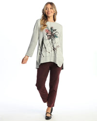 Woman wearing burgundy ankle pants styled with a gray floral top