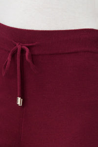 Close-up of burgundy knit jogger pants waistband with drawstring detail
