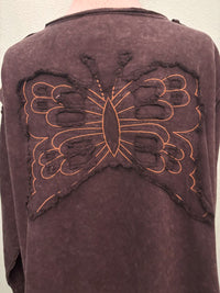 Close-up of brown sweatshirt with large orange butterfly applique on the back