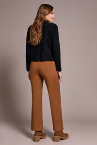 Back view of woman wearing caramel straight-leg pants with a black sweater and brown platform shoes