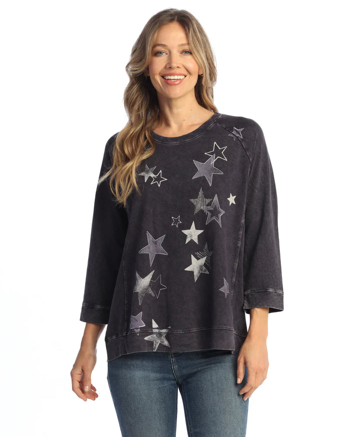 Closeup of woman in black star print sweatshirt with a cheerful smile
