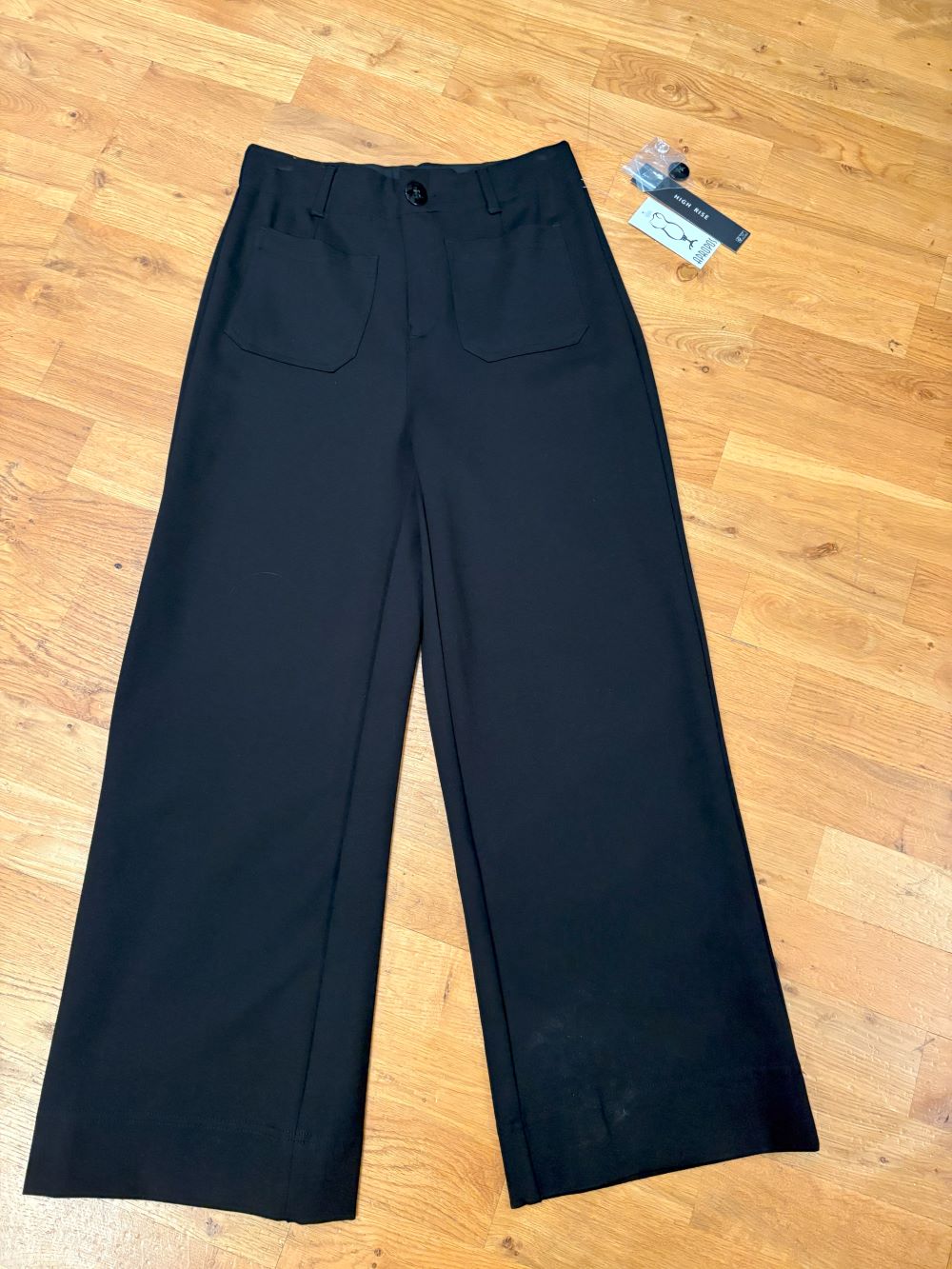 Back view of wide-leg black dress pants on model