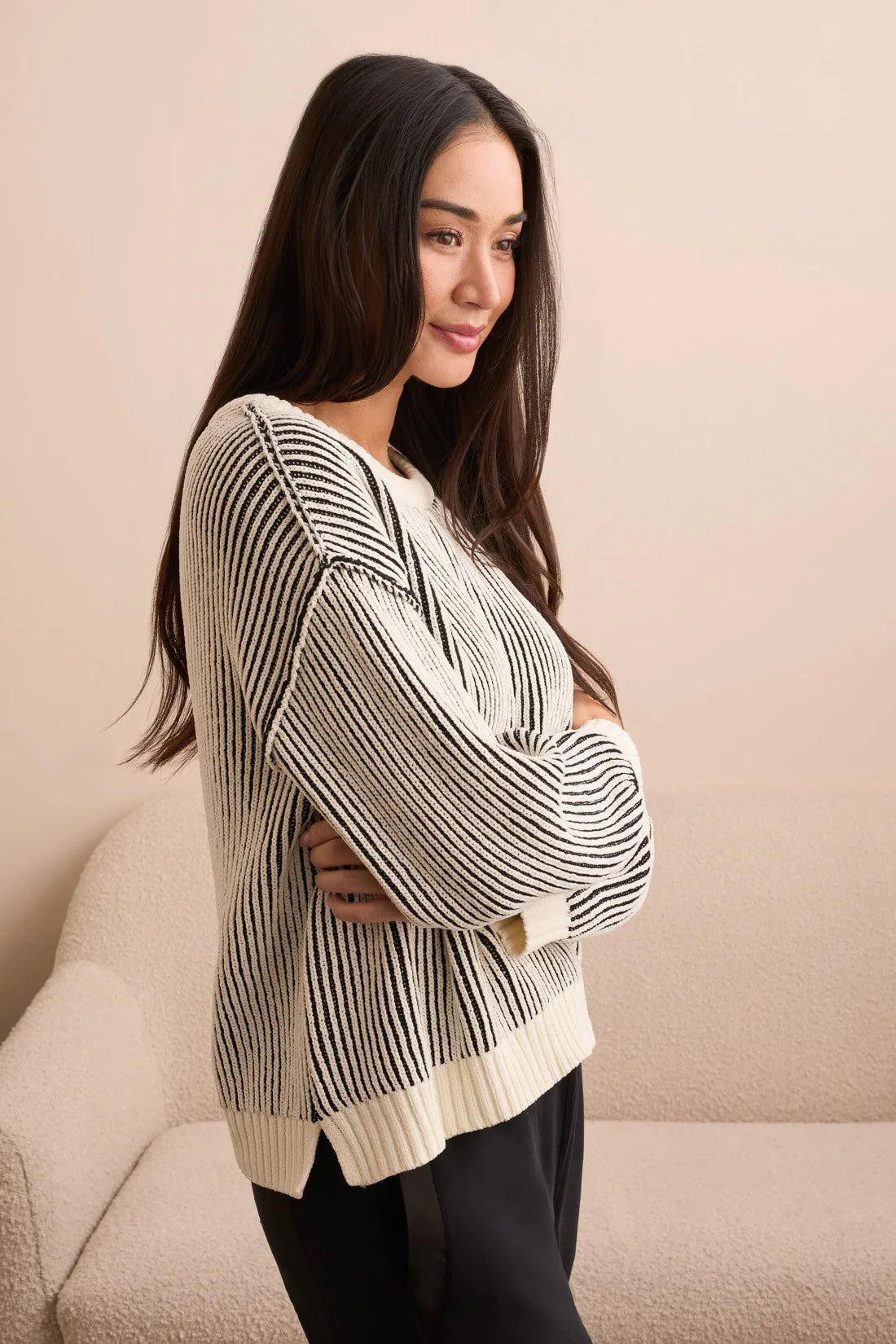 Close-up side view of a woman wearing a monochrome striped knit sweater with cozy texture