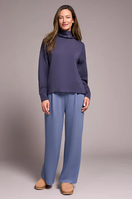 Front view of a woman in a matching navy turtleneck top and light blue lounge pants outfit