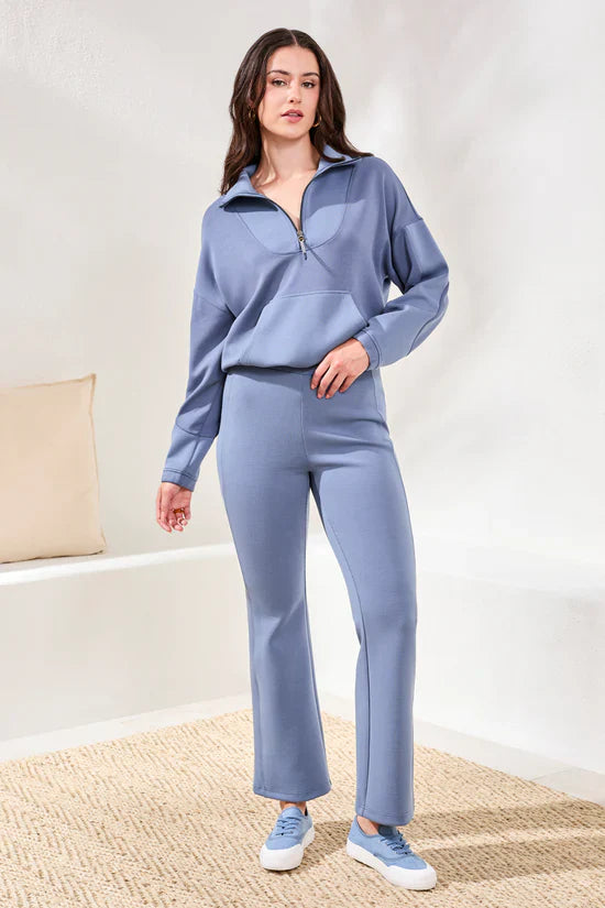 Full front view of a woman in a stylish lavender lounge set with a half-zip top and matching pants