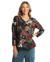 Close-up of smiling woman in a black floral pullover with autumn colors