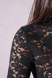Close-up of detailed black floral lace fabric on the turtleneck top