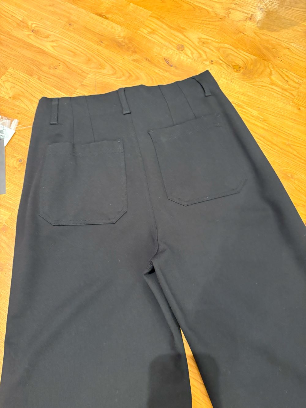 Close-up of back pockets on black wide-leg dress pants