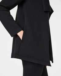 Close-up of cardigan pocket and sleeve details in soft black fabric